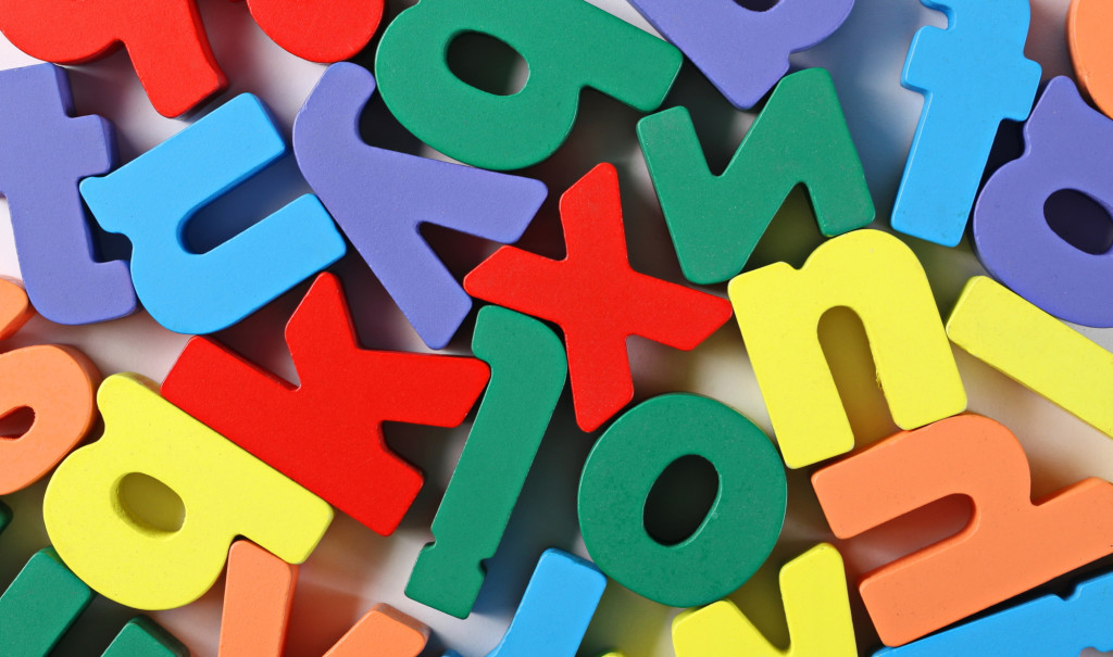 Colourful wooden alphabet letters isolated on white background and texture, top view