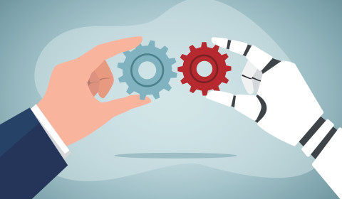 A human hand and robot hand holding two different cogs together being red and blue.