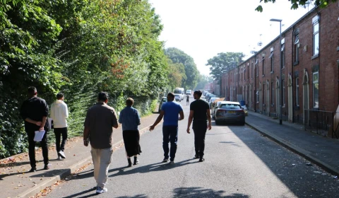 Photograph of people walking down a street