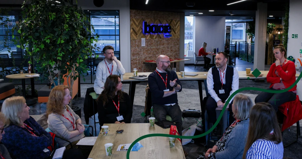 A group of people in smart casual business attire sat around a table, deep in conversation